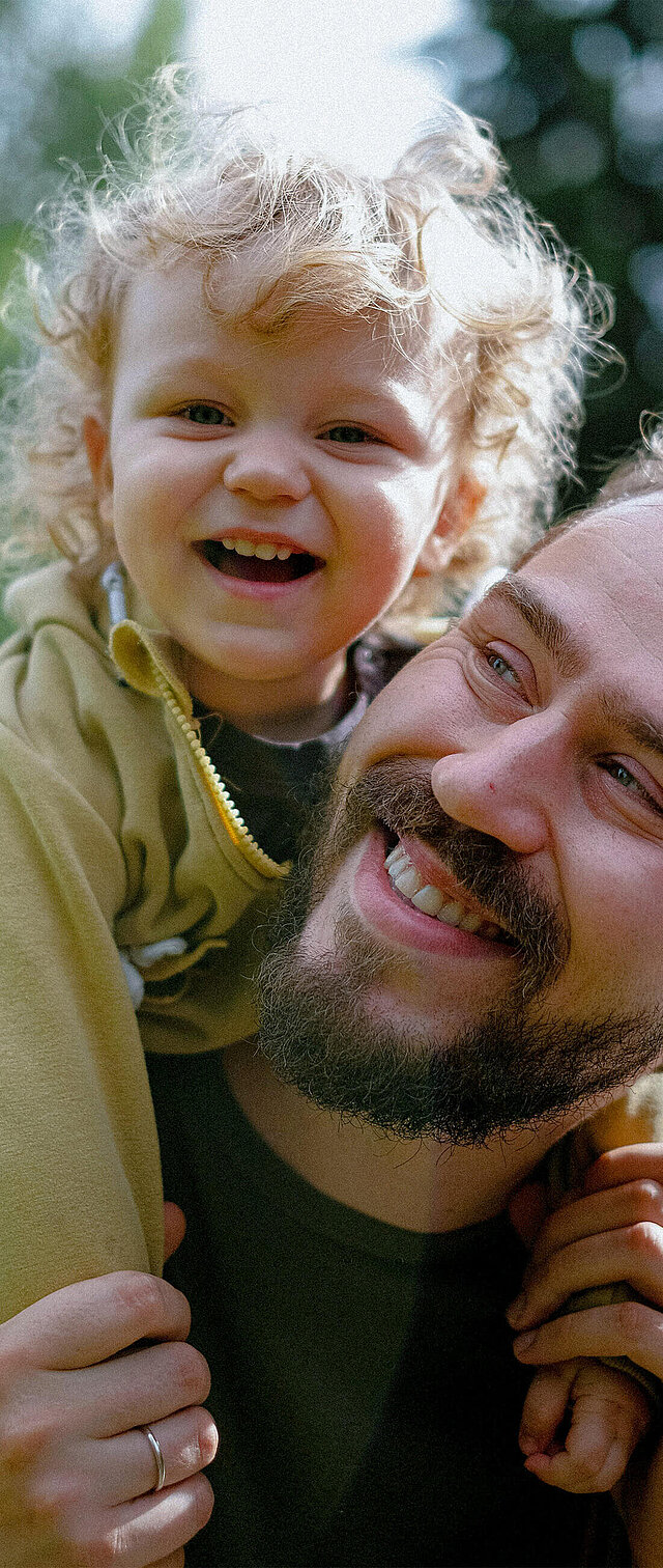 Ein Vater mit seinem Sohn freut sich, weil er die private Krankenversicherung der DONAU abgeschlossen hat. 