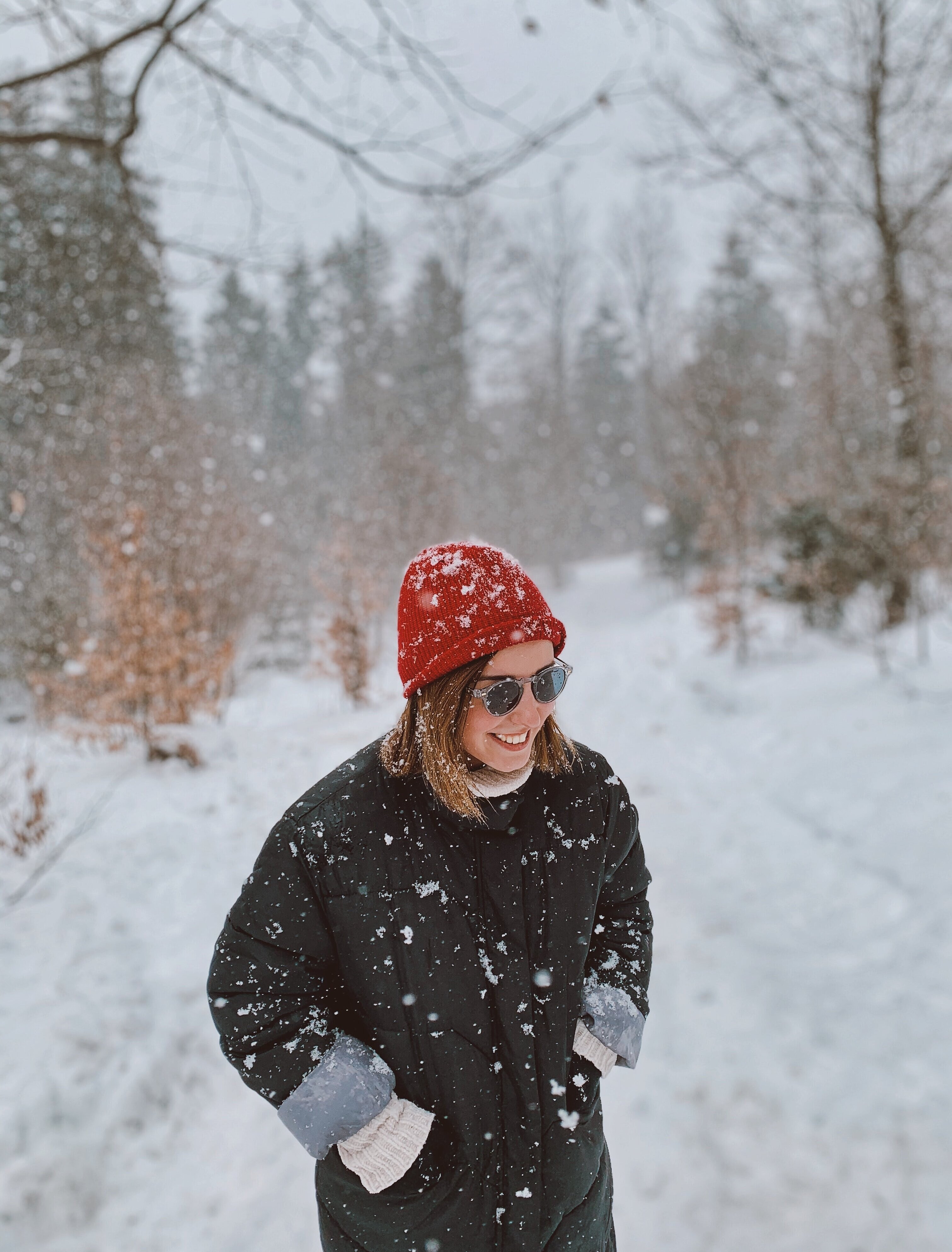 Junge Frau genießt die Winterlandschaft und möchte sich über die Unfallvermeidung im Winter informieren.